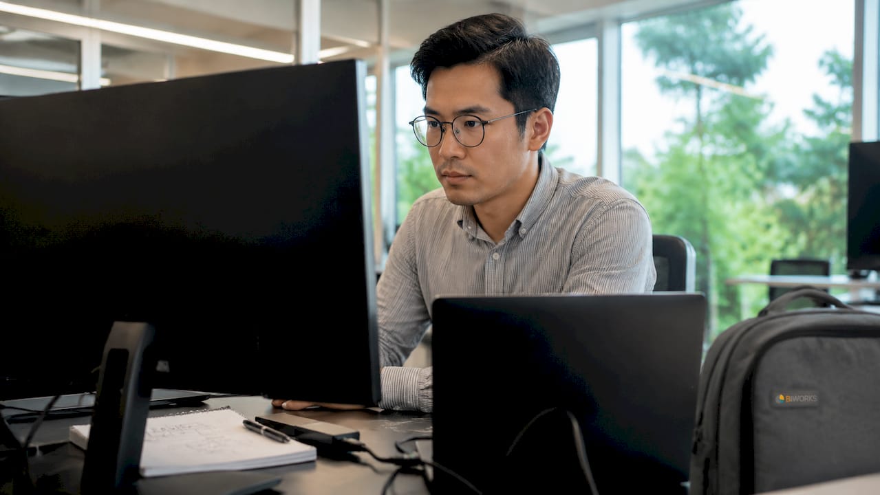 Un technicien en informatique en train de contrôler l’état des serveurs via leurs tableaux de bord.