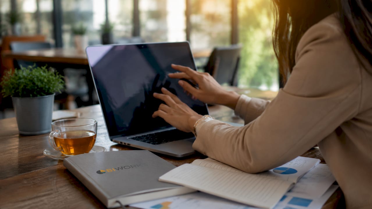 Des mains en pleine utilisation d’une tablette graphique pour visualiser des données sur Power BI