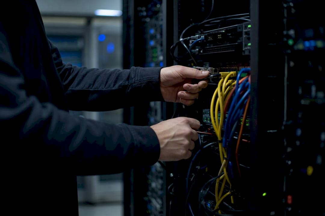 Hands managing network cables in server room