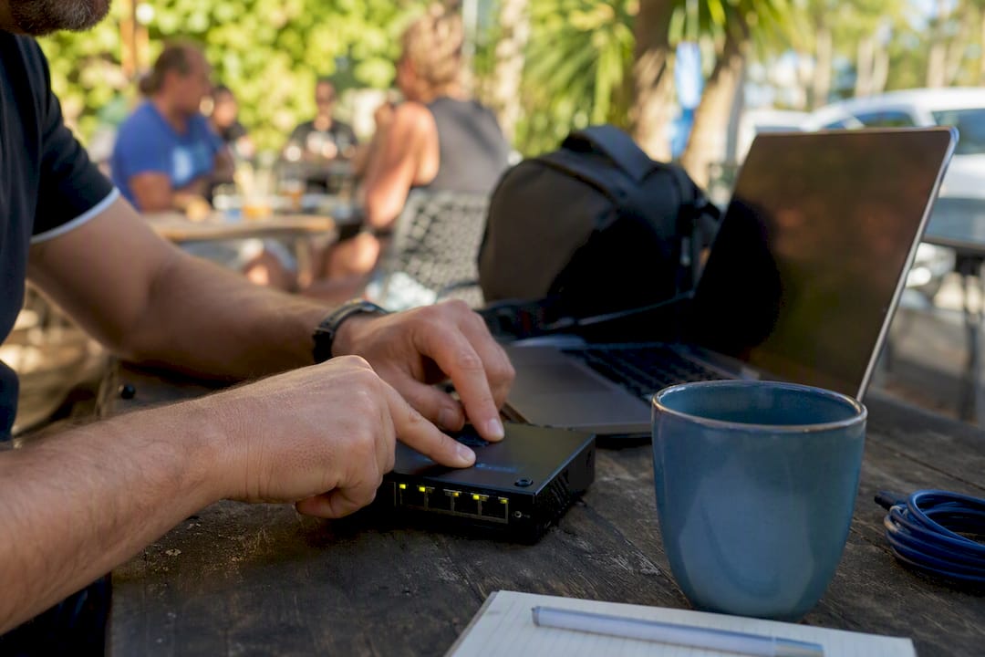 Hands pressing buttons on network device for update