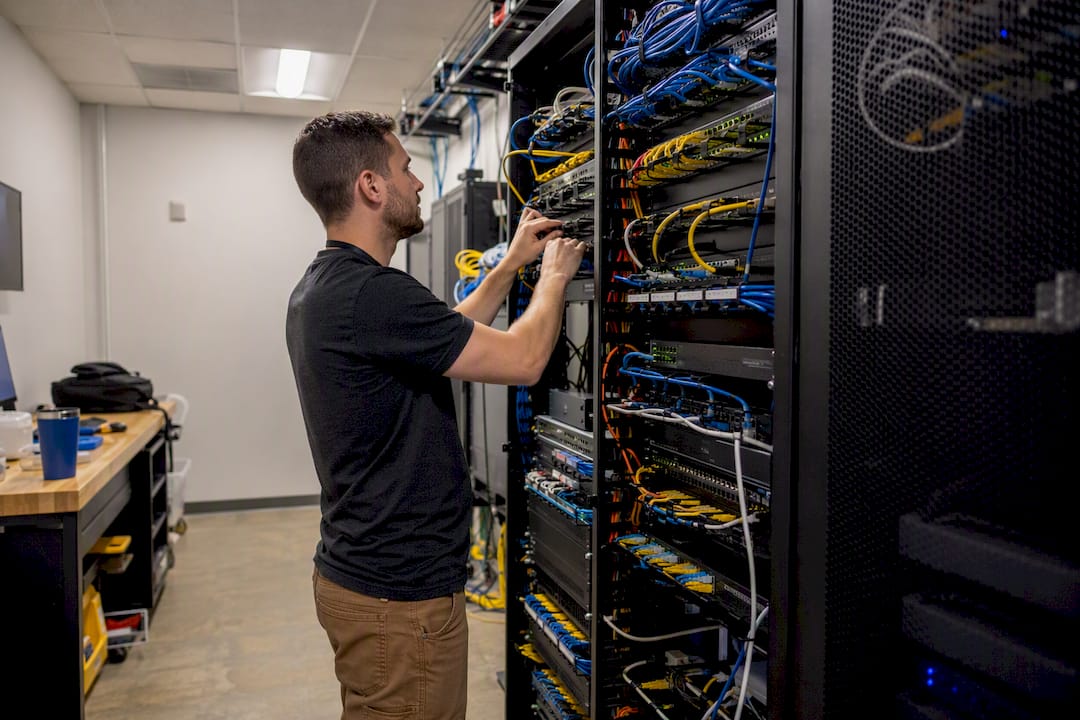 Hands securing network hardware during cybersecurity remediation