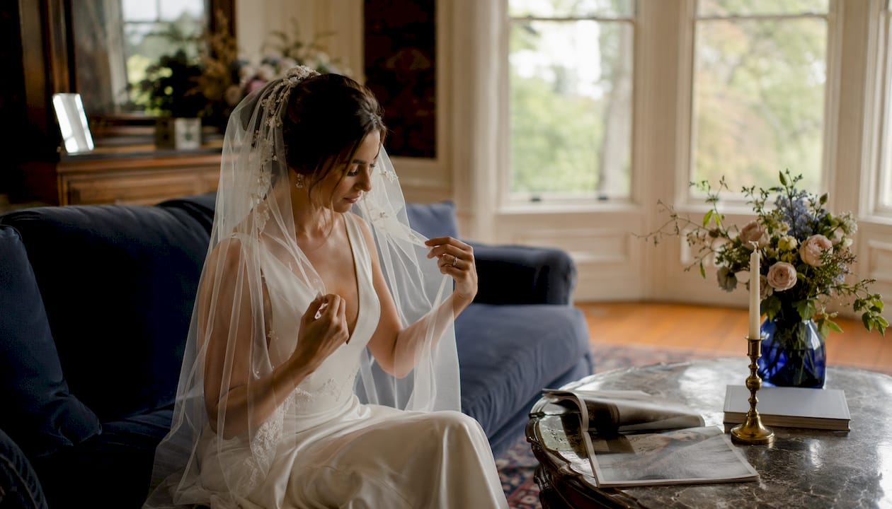 Bride model adjusting veil in studio