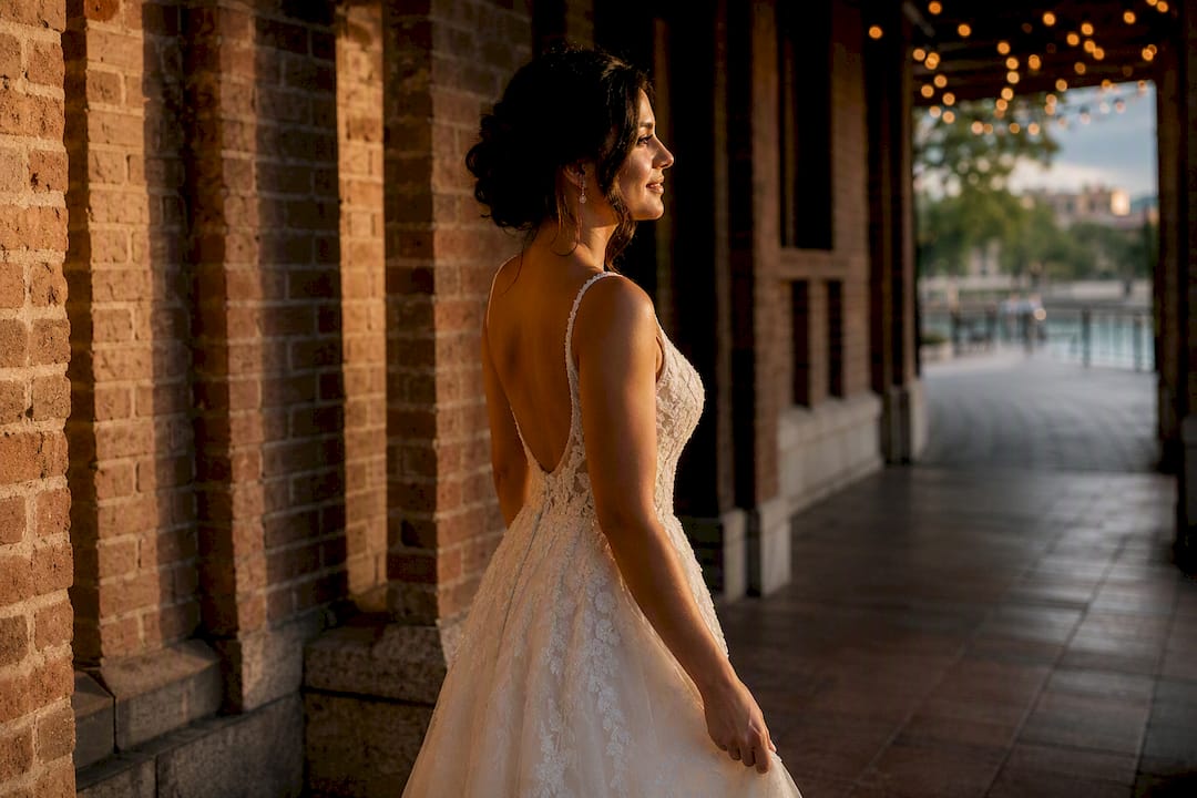 Bride walking beside Pearl brick architecture