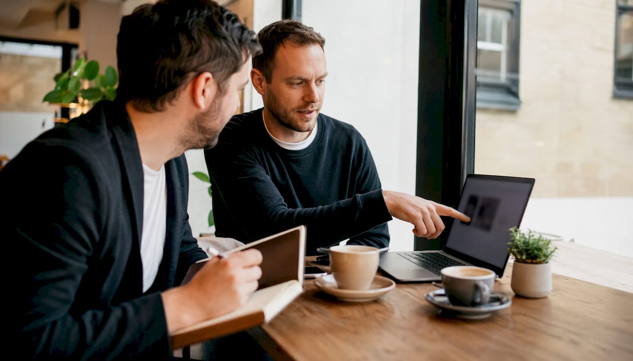 Two men discussing digital agencies in small office