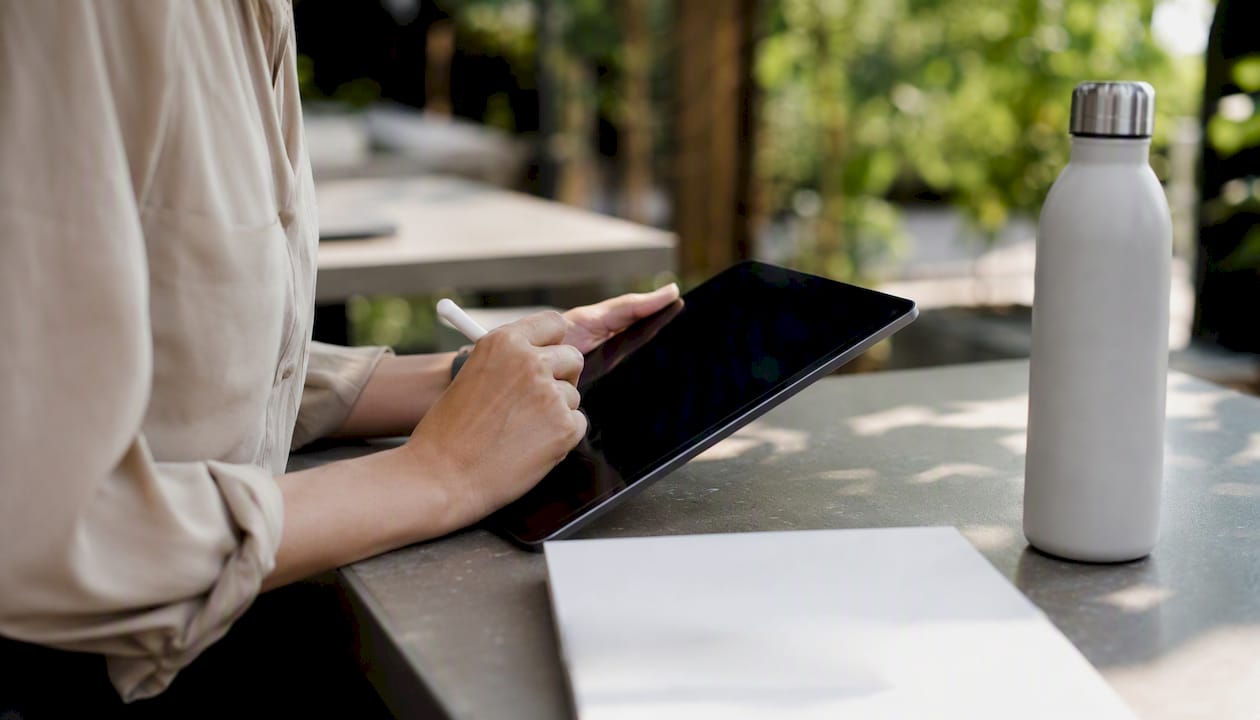 Hands composing outreach email on tablet