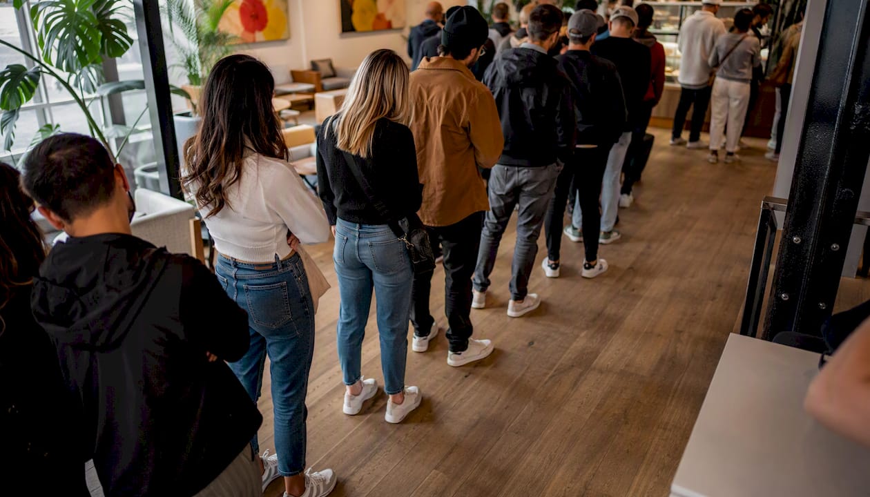 Queue outside busy café on street