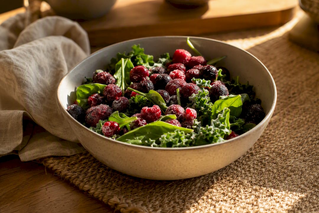 Frozen berries and leafy greens in bowl