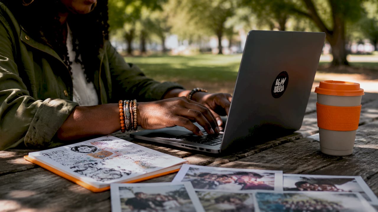 Hands typing community content on laptop