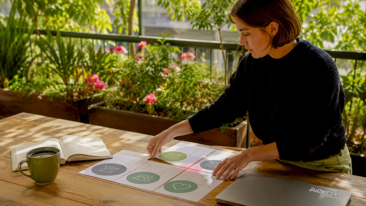Hands organizing key content pillars on a desk.