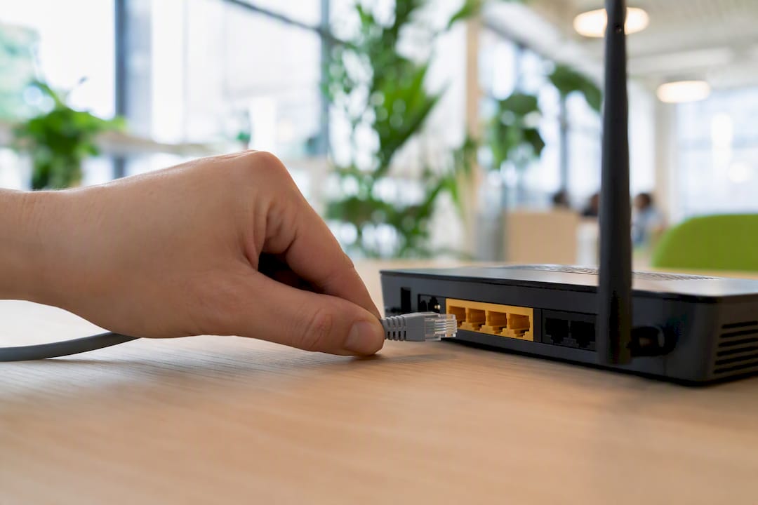 Roka, ki povezuje mrežni kabel na usmerjevalnik