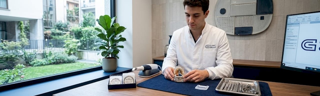 Un dentista esamina un modello ortodontico posato sulla scrivania