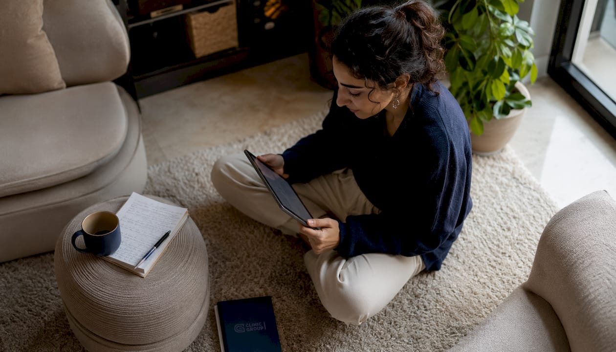 Una donna consulta le recensioni di medici sul suo tablet comodamente a casa.