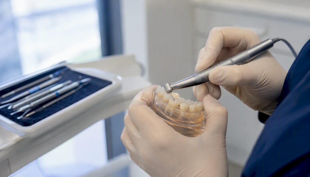 Hands preparing tooth enamel in dental clinic