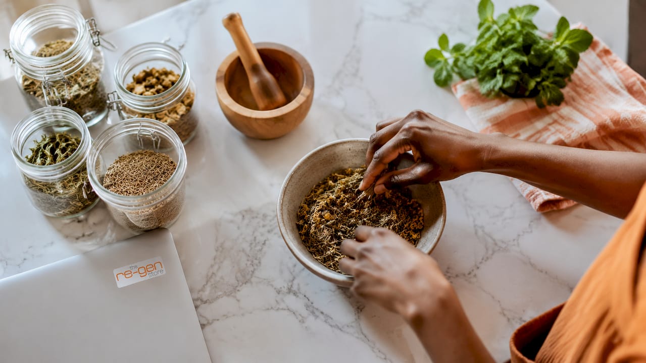 Hands preparing herbal mixture in kitchen