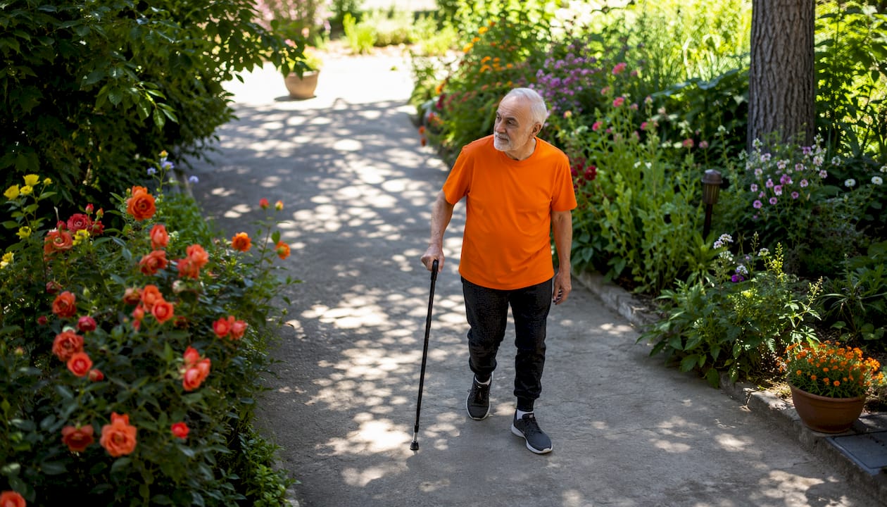 Senior man walking indoors for post-op recovery