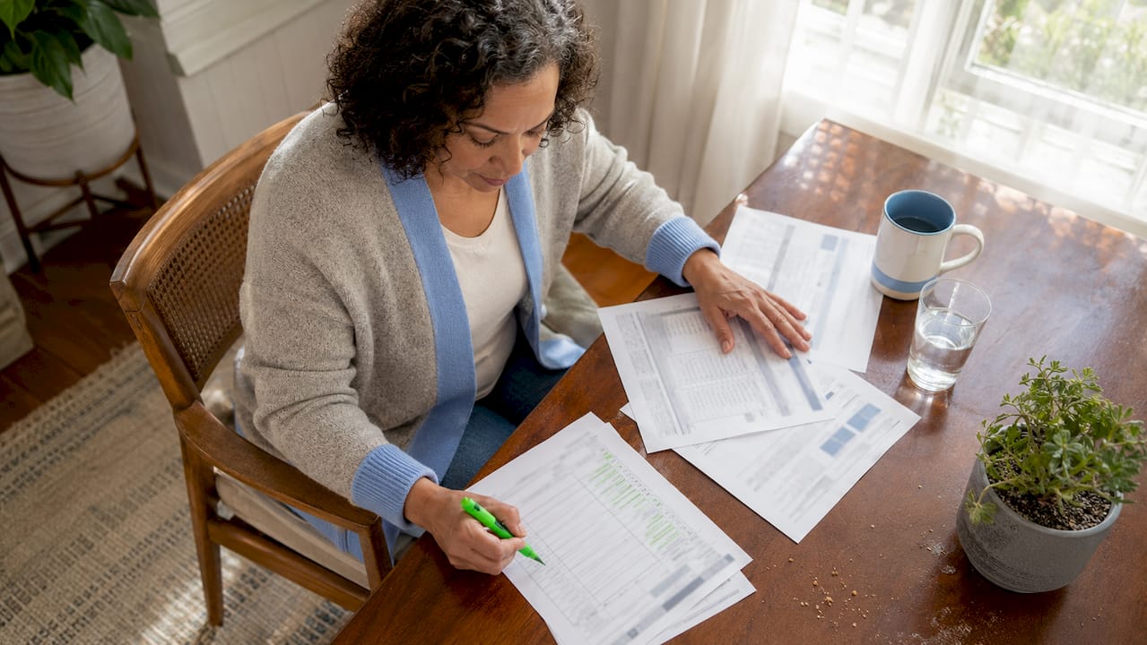 Homeowner reviewing contractor bids at kitchen table