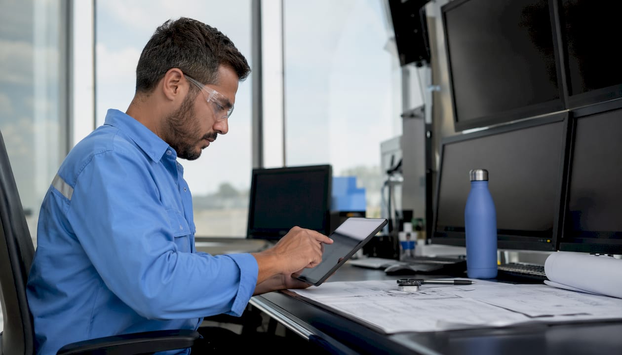 Supervisor using tablet in industrial control room