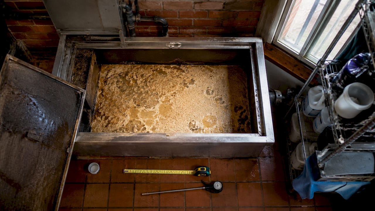 Overhead view of cooled grease trap with measurement tools