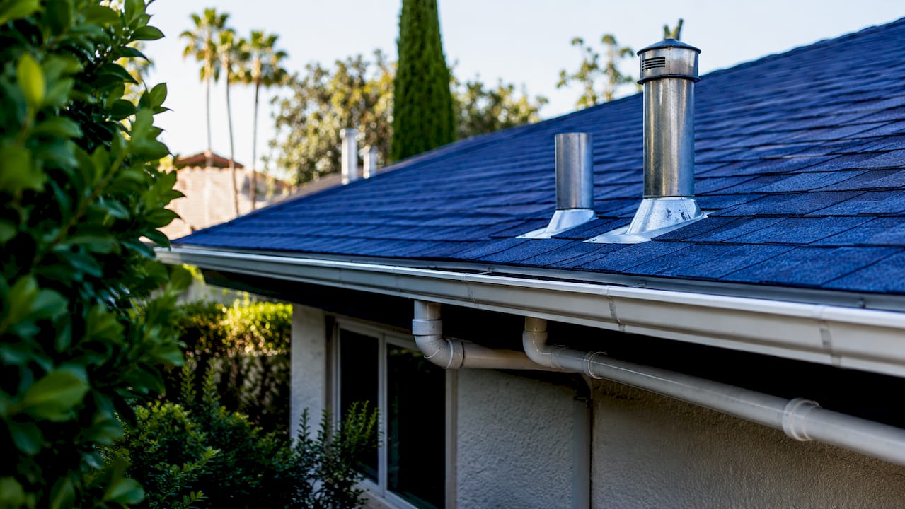 Plumbing vent pipes extending through home roof outdoors