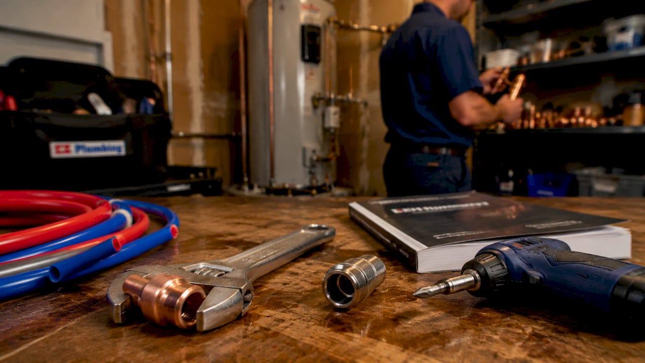 Close-up of plumbing tools and piping on workbench