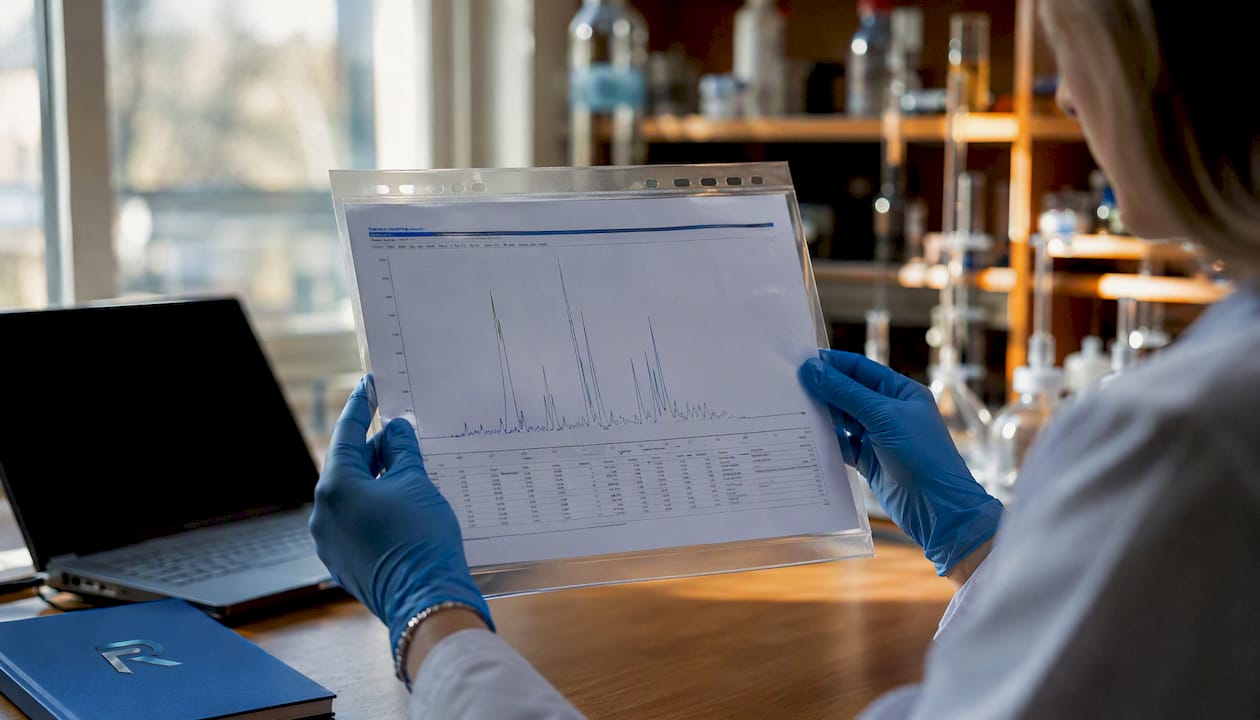 Hands examining HPLC chromatogram printout