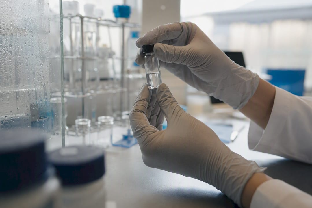 Hands holding peptide vial in lab