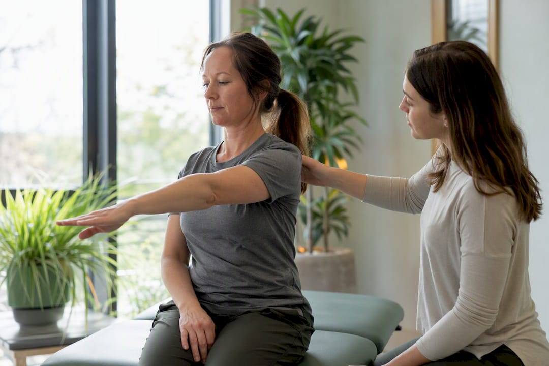 Patient doing gentle scapular exercise guided by therapist