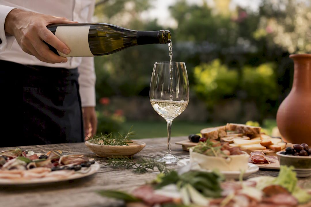Sommelier pouring red wine over food