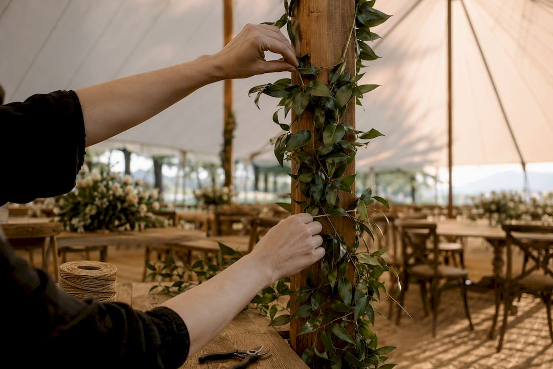 Greenery wrapped around sailcloth tent pole