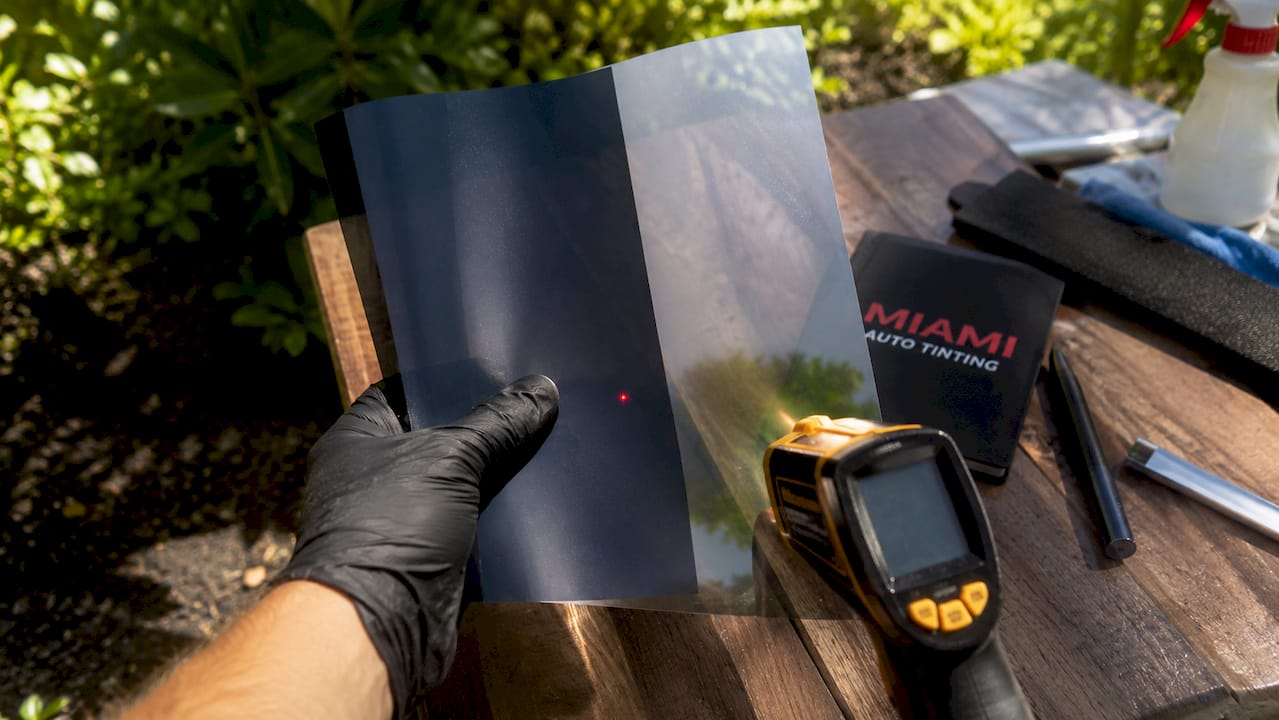 Tint films held for heat rejection comparison indoors