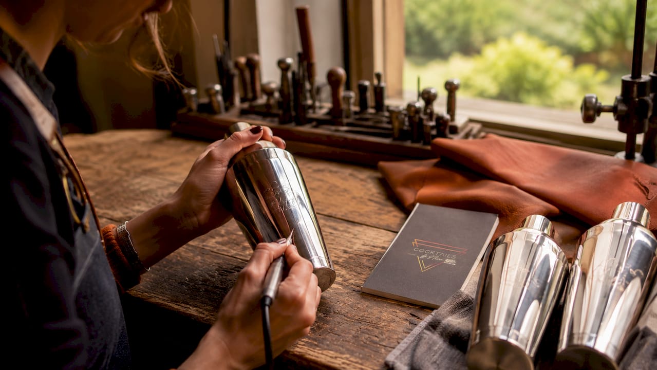 Detailopname van een hand die een cocktailshaker graveert