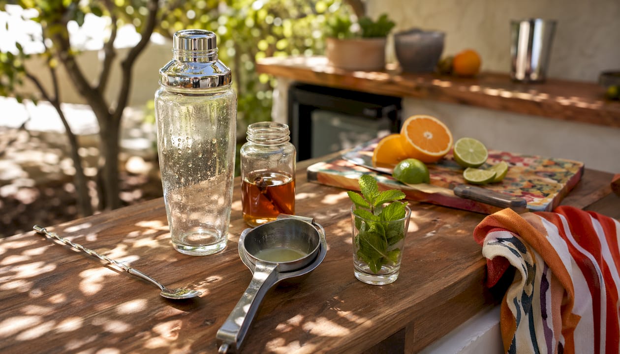 Een detailfoto van de essentiële bartender tools en de ingrediënten voor een cocktail.