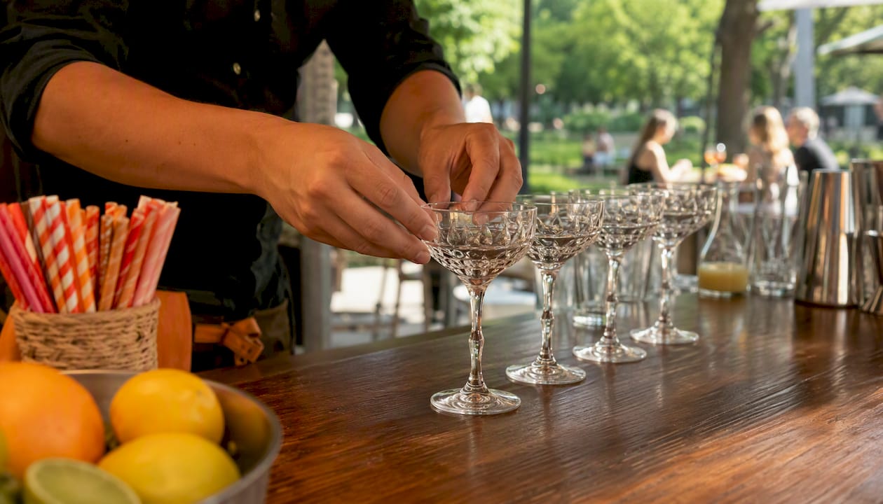 De barman kiest zorgvuldig dezelfde glazen uit voor de bar op het evenement.