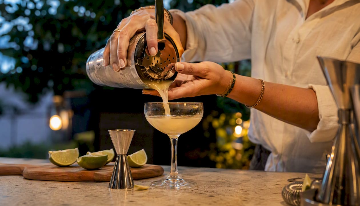 Met een vaste hand wordt er thuis aan de bar een heerlijke cocktail ingeschonken.