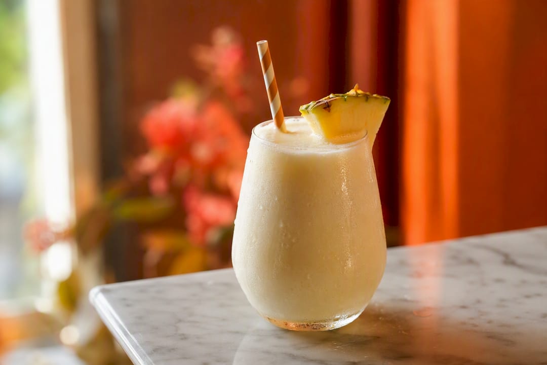 Romige alcoholvrije piña colada in een glas met ananas