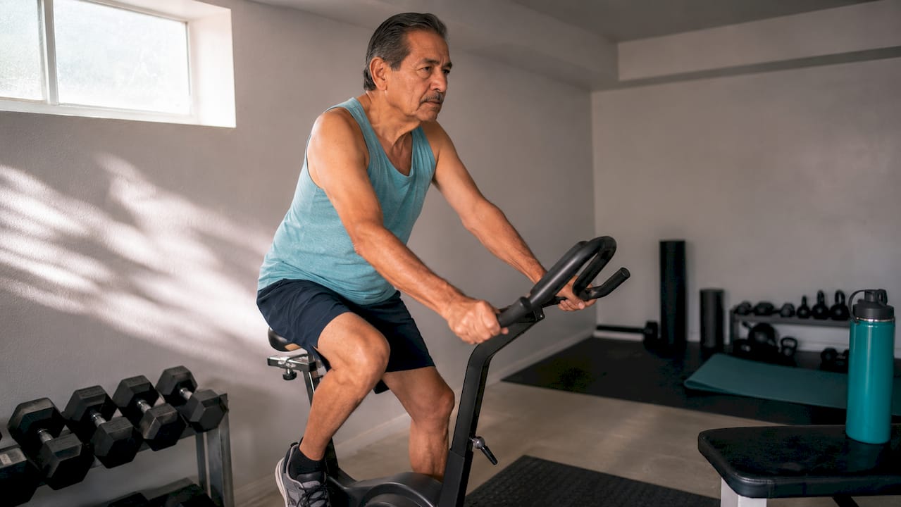 Senior man exercising on stationary bike indoors