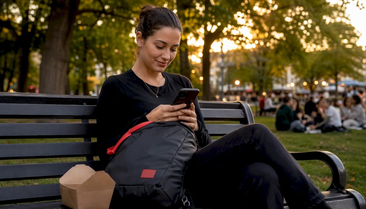 Young woman checking dealership reviews on smartphone at café