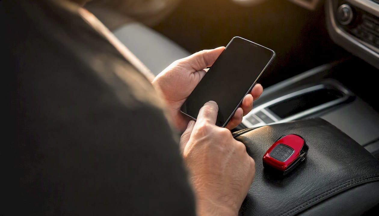 Person’s hands with phone and car keys