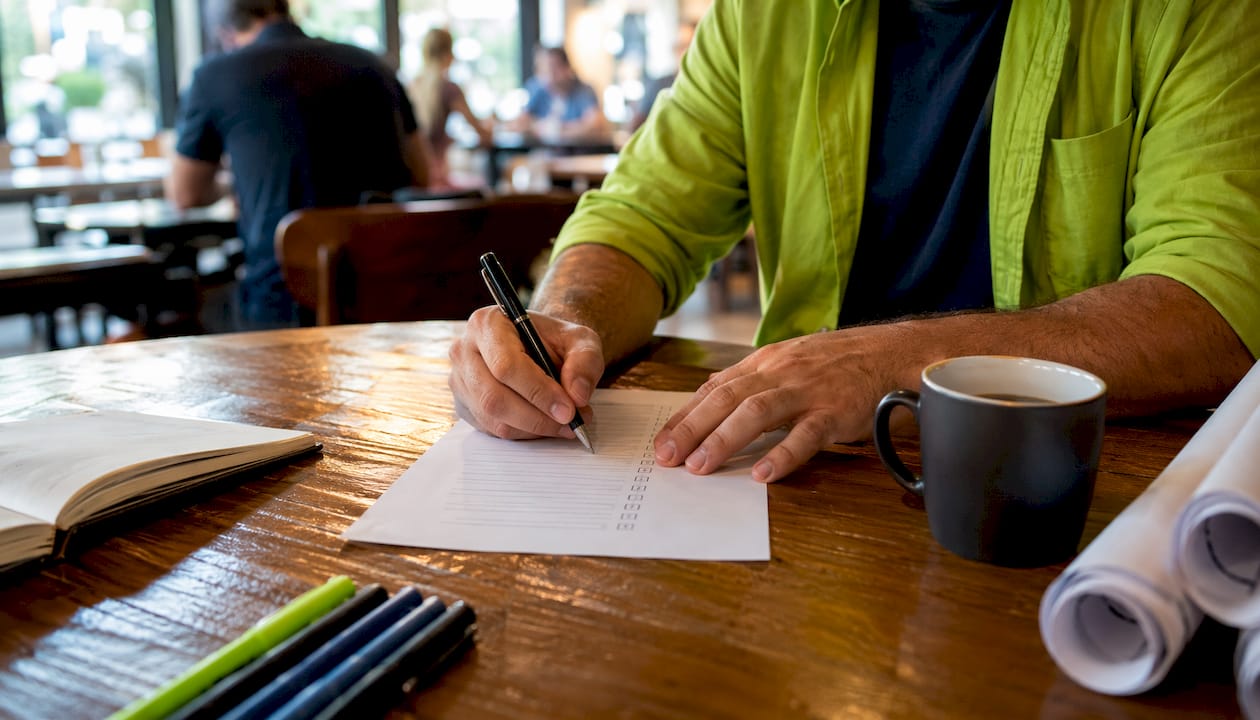 Overhead view of contractor checking lender-ready list
