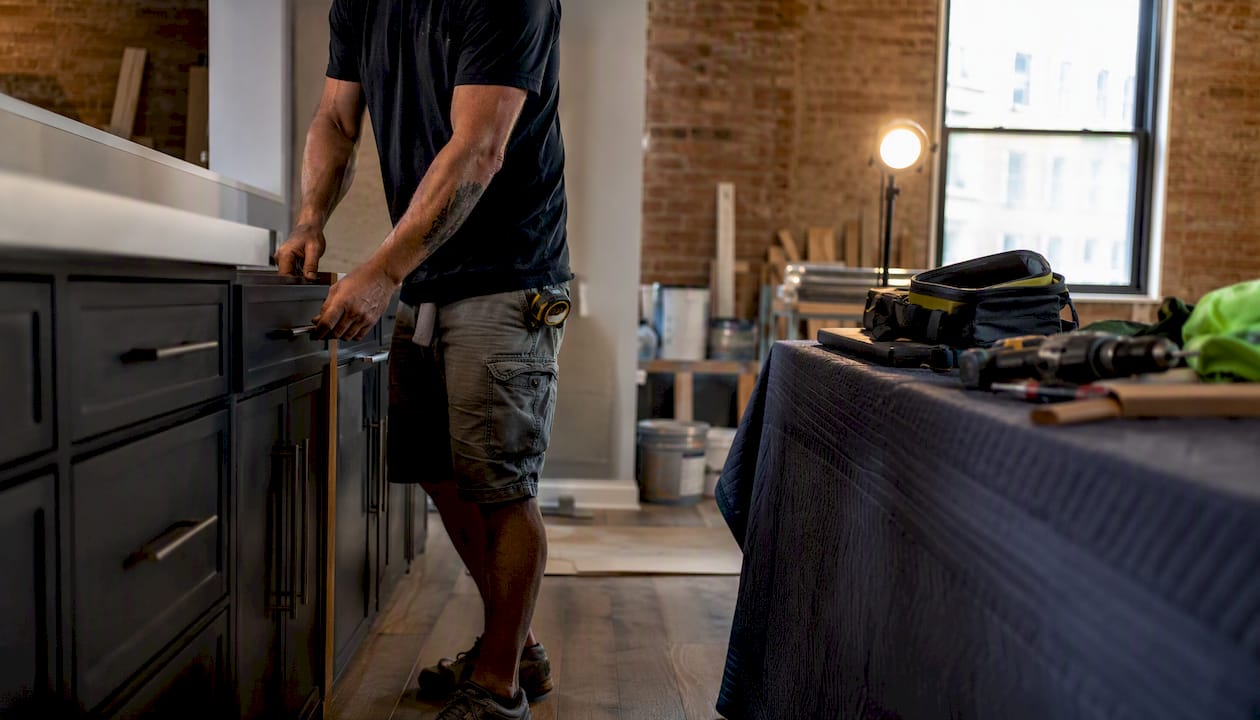 Contractor installing kitchen cabinets in NYC apartment