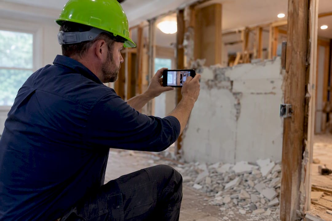 Construction worker photographing renovation site
