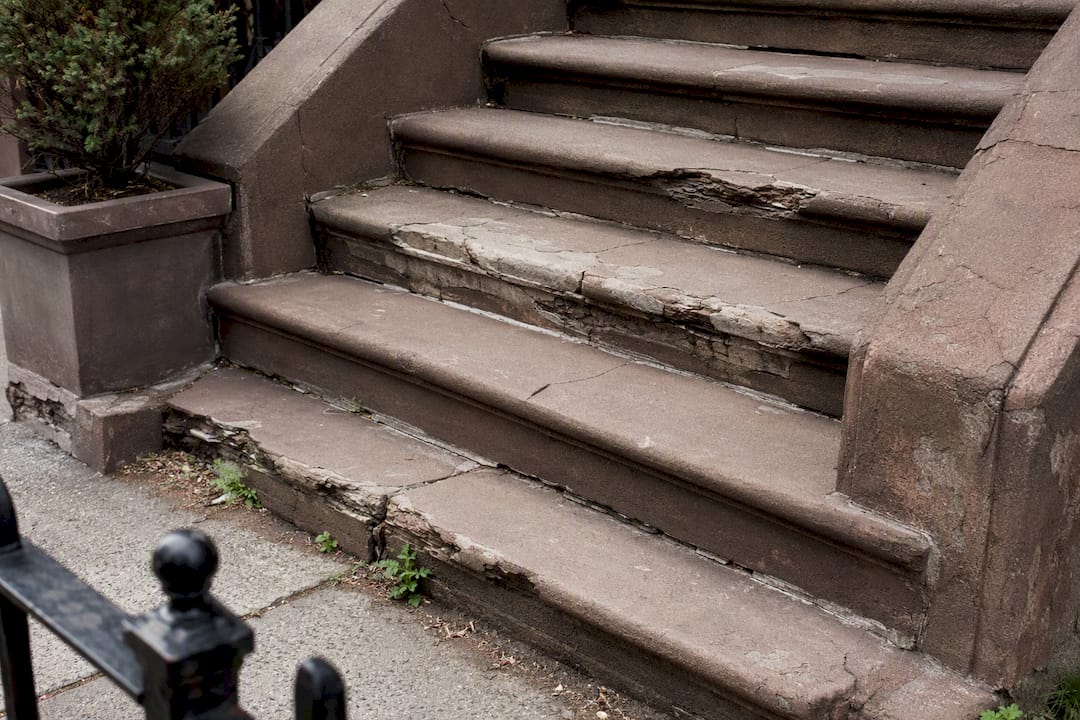 Close-up of damaged brownstone stoop steps