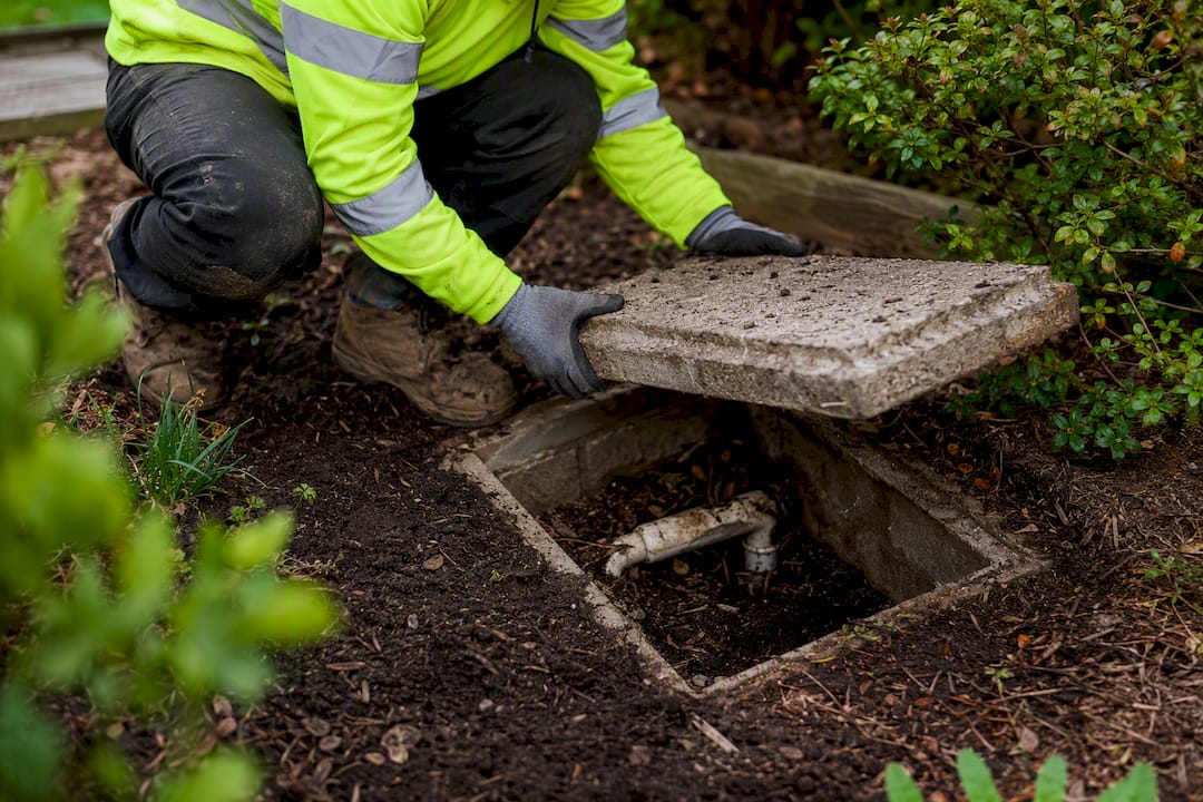 Contractor inspecting septic system at home site