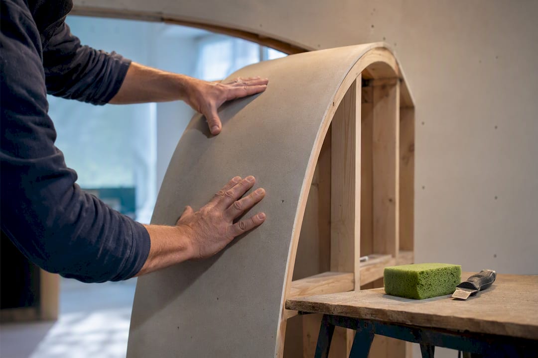 Flexible drywall panel bent around arch
