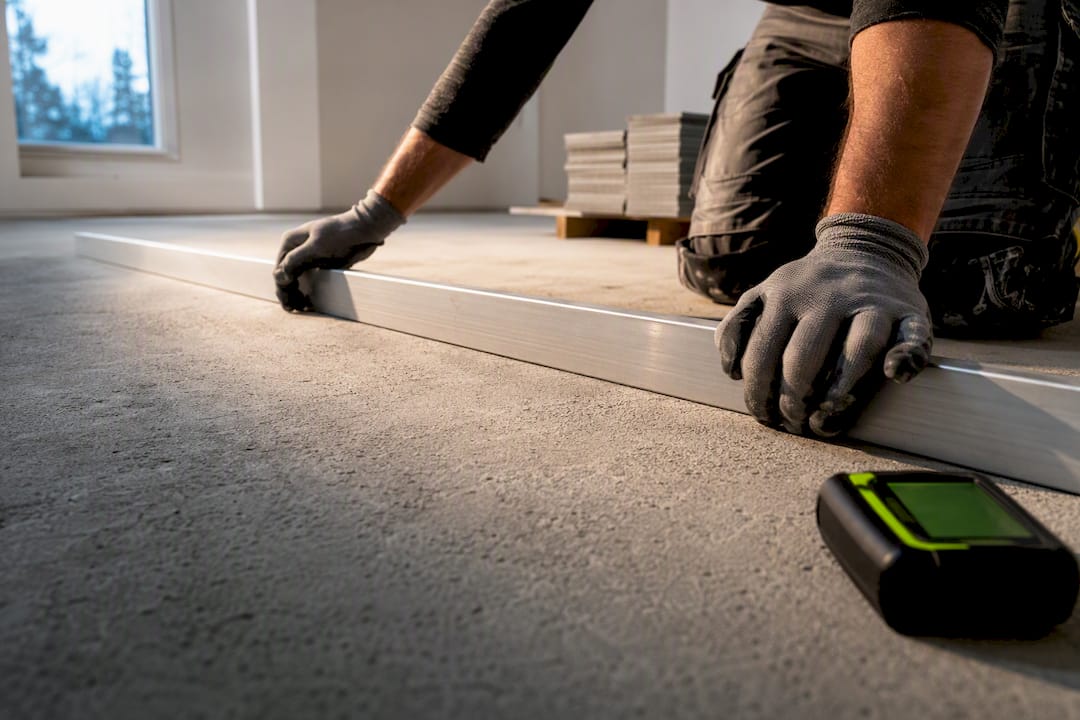 Contractor checking tile subfloor flatness