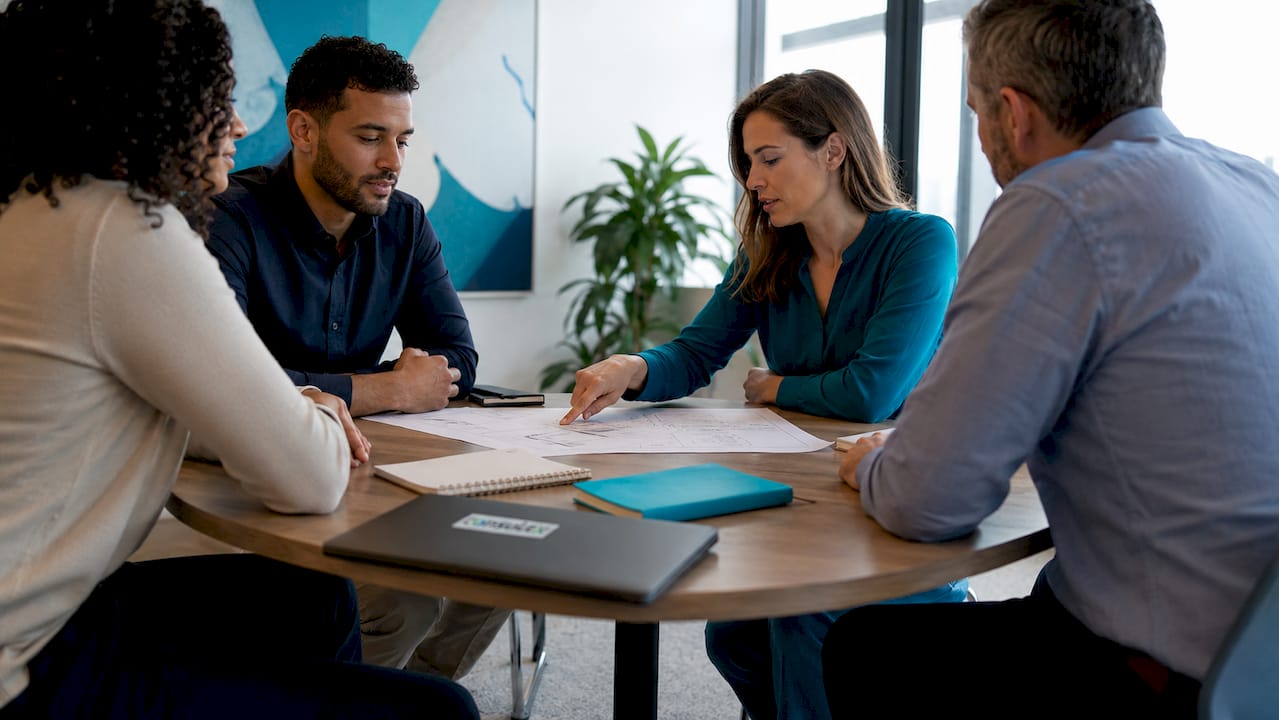 Het zorgteam bespreekt tijdens een overleg de HKZ-kwaliteitsnormen aan de vergadertafel.