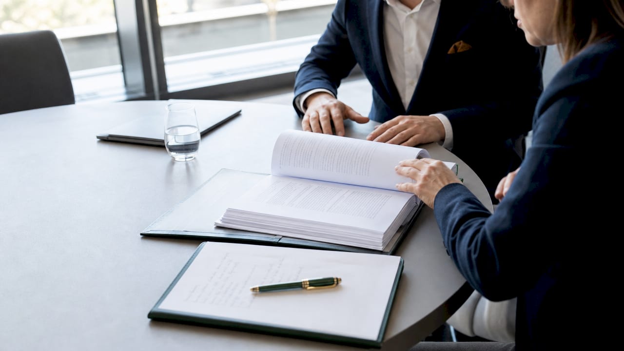 Detailopname van handen die een juridisch document doornemen