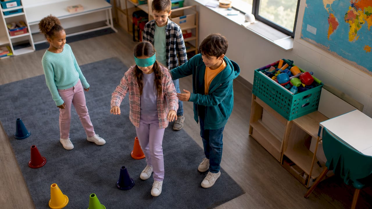 Kids guiding blindfolded teammate in obstacle course
