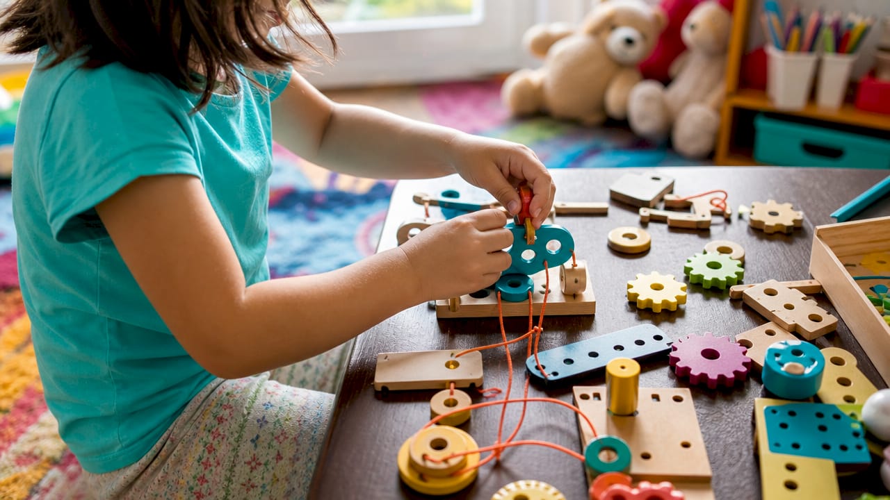 Close-up of hands building brain development toy