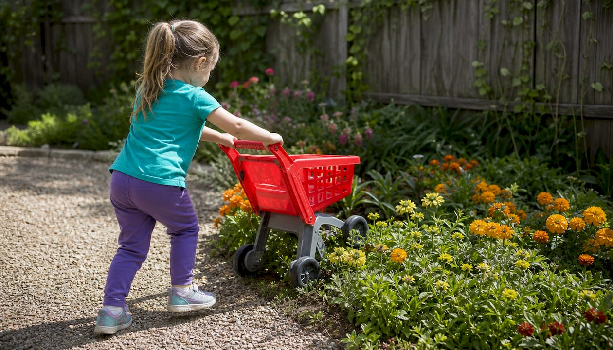 Toy cart wheels transitioning from concrete to grass
